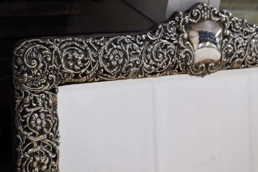 A large Edwardian repousse silver mounted easel frame toilet mirror, Henry Matthews, Birmingham, 1904, 72.8cm.